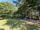 Community playground area with swings and slide, surrounded by mature trees and greenery at 116 Cardell Farms Rd, Locust Grove, GA 30248