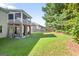 Spacious backyard featuring a well-maintained lawn, a patio, and a screened in porch on the second story at 6131 Sparkling Cove Ln, Buford, GA 30518