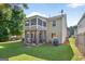 Spacious backyard featuring a well-maintained lawn, a patio, and a screened in porch on the second story at 6131 Sparkling Cove Ln, Buford, GA 30518