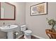 Cozy powder room featuring a pedestal sink, toilet, and decorative accents at 6131 Sparkling Cove Ln, Buford, GA 30518