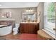 Bathroom featuring double vanity, large window, stylish mirror, and a garden tub at 6131 Sparkling Cove Ln, Buford, GA 30518