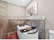 A modern bathtub sits next to the shower featuring tile accents and decorative shelving at 6131 Sparkling Cove Ln, Buford, GA 30518
