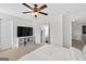 A Primary bedroom with neutral walls, comfortable carpet, television, and a ceiling fan with light at 6131 Sparkling Cove Ln, Buford, GA 30518