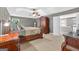 Carpeted main bedroom with a walk-in closet and a large, dark wood armoire at 6131 Sparkling Cove Ln, Buford, GA 30518