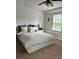 Bright bedroom featuring a large window, ceiling fan, and a comfortable king-size bed at 6131 Sparkling Cove Ln, Buford, GA 30518