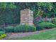 Beautiful brick entrance sign surrounded by lush greenery and colorful flowers at Lanier Springs community at 6131 Sparkling Cove Ln, Buford, GA 30518