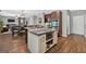 Modern kitchen with stainless appliances, a central island, and an open layout connecting to the living area at 6131 Sparkling Cove Ln, Buford, GA 30518