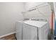 Functional laundry room equipped with a modern washer and dryer and shelving for storage at 6131 Sparkling Cove Ln, Buford, GA 30518