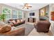 Cozy living room showcasing large windows, a ceiling fan, and a fireplace at 6131 Sparkling Cove Ln, Buford, GA 30518