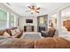 Cozy living room showcasing large windows, a ceiling fan, and a fireplace with decor at 6131 Sparkling Cove Ln, Buford, GA 30518