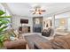 Cozy living room showcasing large windows, a ceiling fan, and a fireplace at 6131 Sparkling Cove Ln, Buford, GA 30518