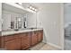 A bathroom with a large mirror, granite countertops, wood cabinets, and double sinks at 110 Sunflower St, Tyrone, GA 30290
