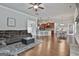 Open-concept living area with hardwood floors, kitchen, and a brown sectional sofa at 110 Sunflower St, Tyrone, GA 30290