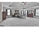 Spacious main bedroom with a tray ceiling, ceiling fan, and multiple windows with dark curtains at 110 Sunflower St, Tyrone, GA 30290