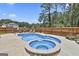 Backyard pool and hot tub surrounded by a wooden fence and lush greenery, perfect for outdoor relaxation at 110 Sunflower St, Tyrone, GA 30290