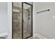 A modern shower with gray tile, a glass door, and a shower head and a hand shower at 110 Sunflower St, Tyrone, GA 30290