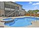 A spacious pool with a connected spa, surrounded by patio furniture and a covered porch at 110 Sunflower St, Tyrone, GA 30290