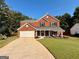 Charming two-story brick home featuring a well-maintained front lawn and attached two-car garage at 5388 Silver Springs Dr, Sugar Hill, GA 30518