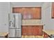 Well-lit kitchen showcasing stainless steel refrigerator, wooden cabinets, and granite countertops at 747 Gardenside Cir, Marietta, GA 30067