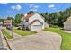 View of the home showcasing a long driveway leading to a garage and complemented by a lush, green lawn at 7770 Hana Court Ct, Jonesboro, GA 30236