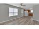 Well-lit living room with hardwood flooring, ceiling fan, and neutral walls flowing into kitchen at 7770 Hana Court Ct, Jonesboro, GA 30236