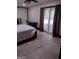 A bedroom featuring light-colored floor tiles, a bed, and sliding glass doors to the outside at 5840 Butner Rd, South Fulton, GA 30349