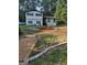 Charming two-story home with a landscaped front yard, black trim, and a manicured garden at 5840 Butner Rd, South Fulton, GA 30349
