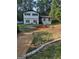 Charming two-story home with a landscaped front yard, black trim, and a manicured garden at 5840 Butner Rd, South Fulton, GA 30349