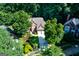 Aerial view of a two-story brick home featuring a well-manicured lawn and mature trees at 3245 Bywater Trl, Roswell, GA 30075