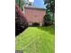 A well-manicured backyard features lush green grass, a brick house, and landscaping at 3245 Bywater Trl, Roswell, GA 30075