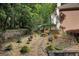 The lovely backyard has a tranquil garden, mature trees, stone pathway, and custom landscape at 3245 Bywater Trl, Roswell, GA 30075