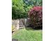 Backyard stone steps lead to an outdoor landscape with mature shrubs and a wooded view at 3245 Bywater Trl, Roswell, GA 30075