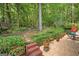 Lush backyard featuring garden steps, patio with potted plants, and wooded surroundings, creating a peaceful outdoor oasis at 3245 Bywater Trl, Roswell, GA 30075