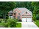An attractive brick home with a two-car garage, well-maintained lawn and mature trees at 3245 Bywater Trl, Roswell, GA 30075