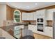 Elegant kitchen features white cabinets, granite countertops, and stainless steel appliances at 3245 Bywater Trl, Roswell, GA 30075