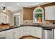 Charming kitchen with black countertops, white cabinets, stainless steel appliances and sunlit window at 3245 Bywater Trl, Roswell, GA 30075