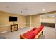 Well-lit living room with a futon, media console, and neutral carpet, creating a functional and inviting space at 3245 Bywater Trl, Roswell, GA 30075