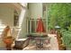 Relaxing outdoor patio with garden fountain, dining table, umbrella, landscaping, and beautiful potted flowers at 3245 Bywater Trl, Roswell, GA 30075