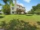 Green backyard featuring mature trees, a trampoline, and a deck with steps at 942 Marta Crane Dr, Lawrenceville, GA 30045