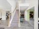 Inviting entryway with a staircase, light hardwood floors, and views into multiple rooms at 942 Marta Crane Dr, Lawrenceville, GA 30045
