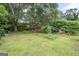Image of a large backyard with big mature trees, a shed, and grass at 178 S Old Highway 27, Roopville, GA 30170
