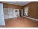 Bright bedroom with a fireplace, windows, ceiling fan, wood-paneled walls, and wood floors, providing comfort at 178 S Old Highway 27, Roopville, GA 30170
