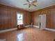 Sunlit bedroom with wood paneled walls, ceiling fan, a window, and wood floors, creating a cozy atmosphere at 178 S Old Highway 27, Roopville, GA 30170