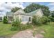 Charming home with a green metal roof, light yellow siding, and a quaint porch with pretty landscaping at 178 S Old Highway 27, Roopville, GA 30170