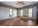 Cozy living room featuring wood floors, large windows, a ceiling fan, and a comfortable couch at 178 S Old Highway 27, Roopville, GA 30170
