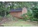 Image of a shed with dark wooden exterior surrounded by greenery at 178 S Old Highway 27, Roopville, GA 30170