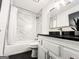 Bathroom with white vanity, black countertop, framed mirror, and a shower-tub combination at 3150 Stratford Green Pl, Avondale Estates, GA 30002