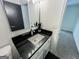 Clean bathroom with a black countertop, white vanity, and a well-lit mirror at 3150 Stratford Green Pl, Avondale Estates, GA 30002
