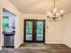 Dining room featuring wood floors, chandelier, and access to kitchen and outdoor space at 3150 Stratford Green Pl, Avondale Estates, GA 30002