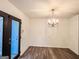 Dining room with modern chandelier, wood-look floors, and door leading outside at 3150 Stratford Green Pl, Avondale Estates, GA 30002